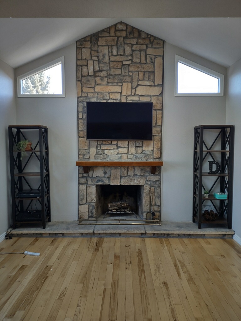 tv mounted over a stone fireplace