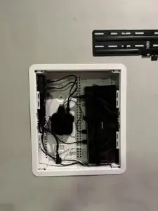 A One Connect box inside a 17-inch media box on a grey wall, with cables and a TV mount visible.