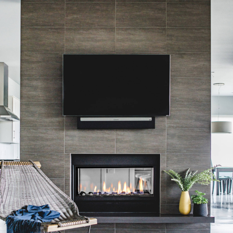 a tv mounted on tile over a fireplace