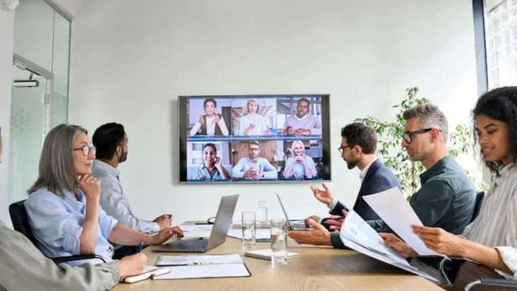 Professional office staff looking at tv mounted on wall