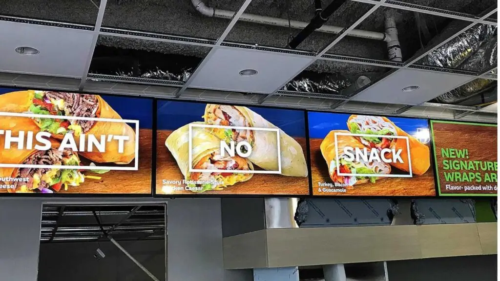 4 tvs with resturant menus displayed on the screen hanging from ceiling