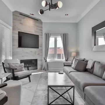 TV Mounted on stone fireplace in white room