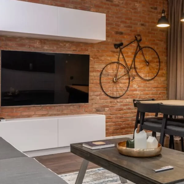 photo of tv mounted on wall next to a rustic bike.