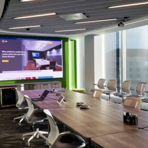 Large tv mounted on the wall in front of a large office table