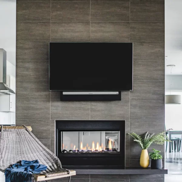 a tv mounted on tile over a fireplace